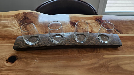 Set of four clear glass tumblers on a wooden tray