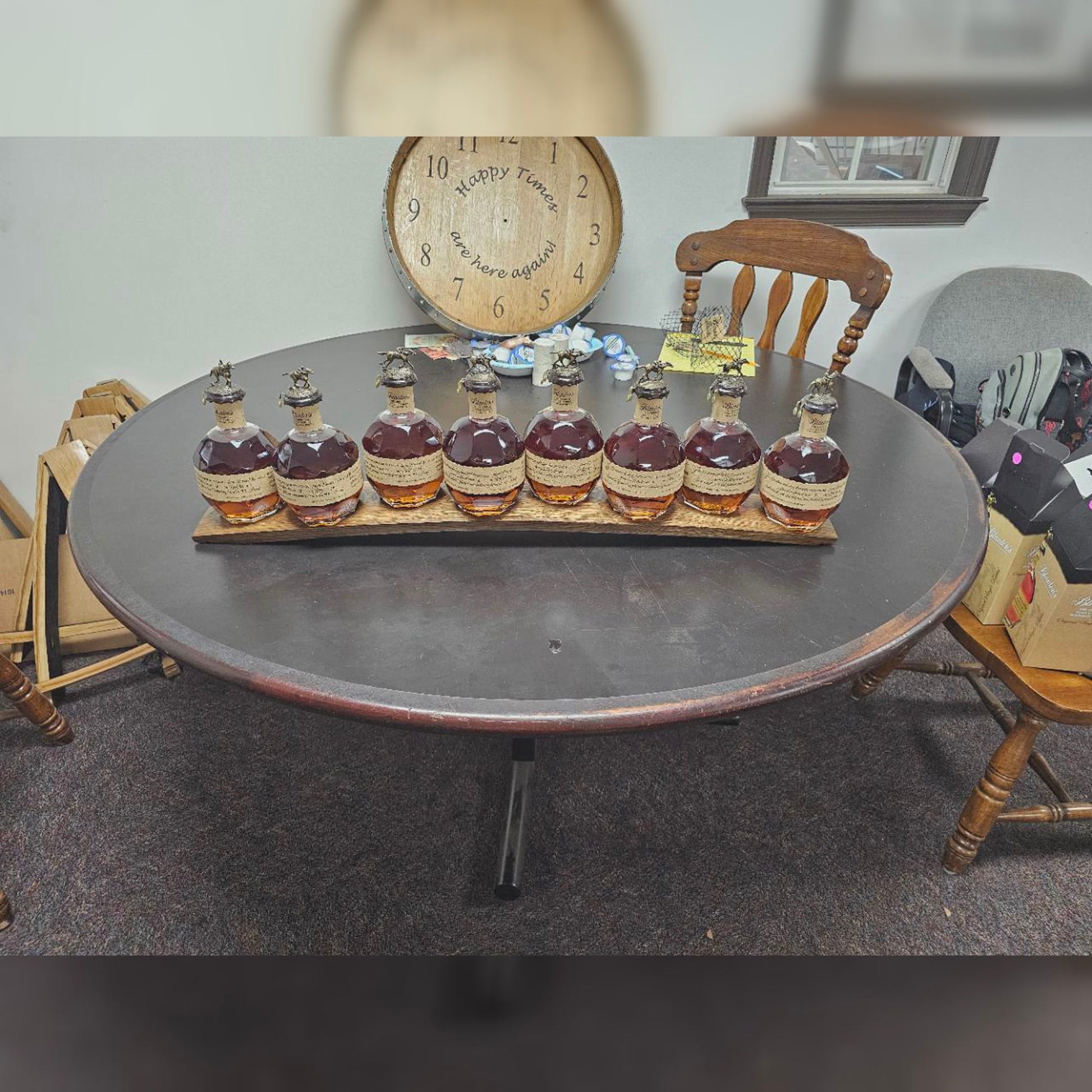 Wide view of eight collector bottles displayed on the reclaimed oak stave; bottles not included.