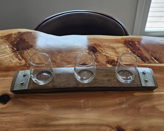 Wooden table with a live-edge design featuring three clear glass holders.