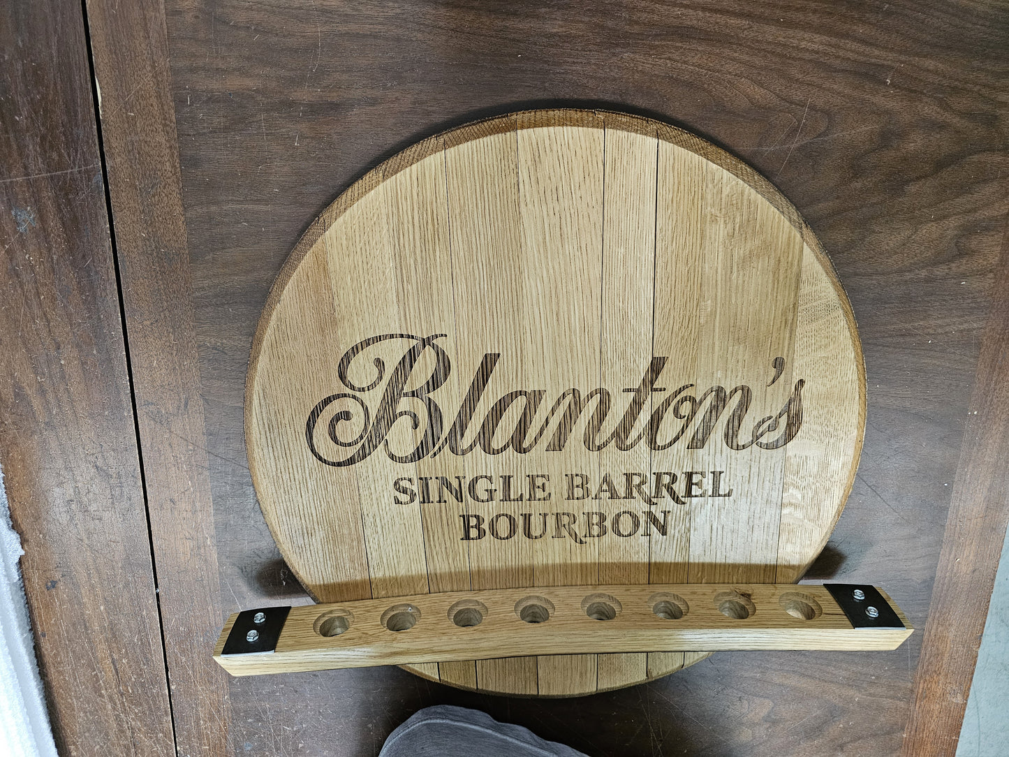 Angled view of the empty eight-position stopper holder attached to an authentic bourbon barrel head.