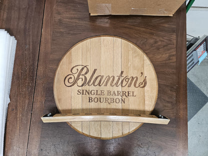 Front view of the empty Blanton's barrel head wall display with eight stopper openings.
