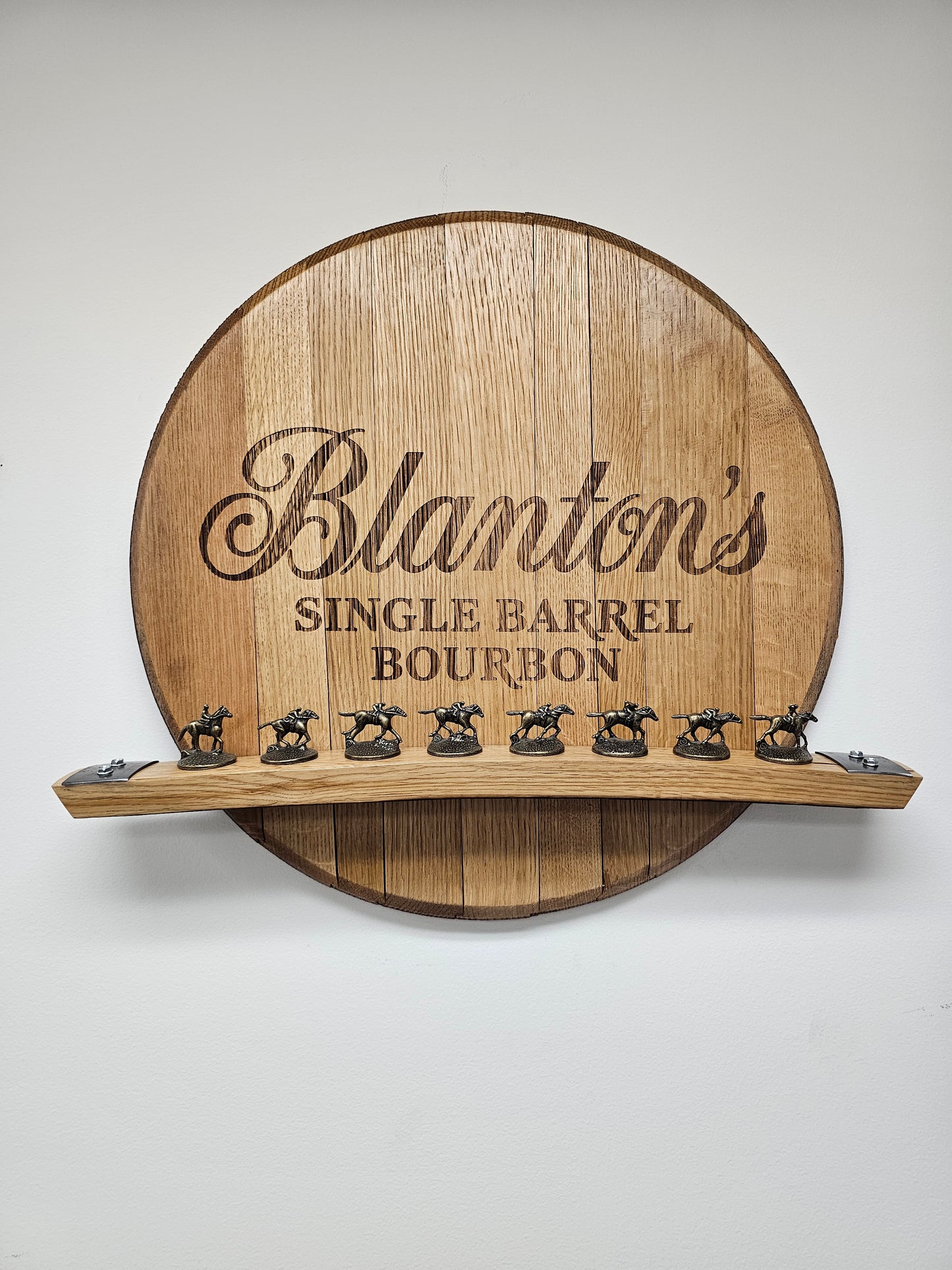 Blanton's engraved bourbon barrel head wall display holding eight horse stoppers; stoppers are not included.