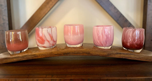 Five Glassybaby candle holders displayed on a reclaimed wine barrel stave stand